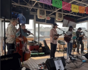 E-Boro Bandits performing, a cello, violin, mandolin and guitar are being played in the photo.